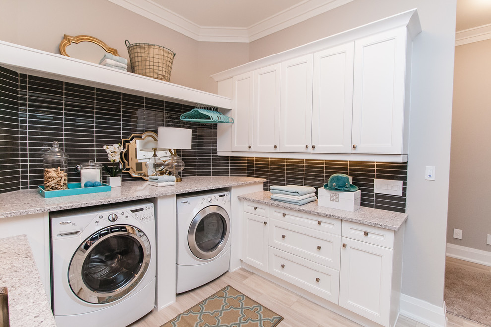 Photo of a transitional l-shaped laundry room in Toronto with recessed-panel cabinets, white cabinets, a side-by-side washer and dryer, beige walls, light hardwood floors, beige floor and beige benchtop.