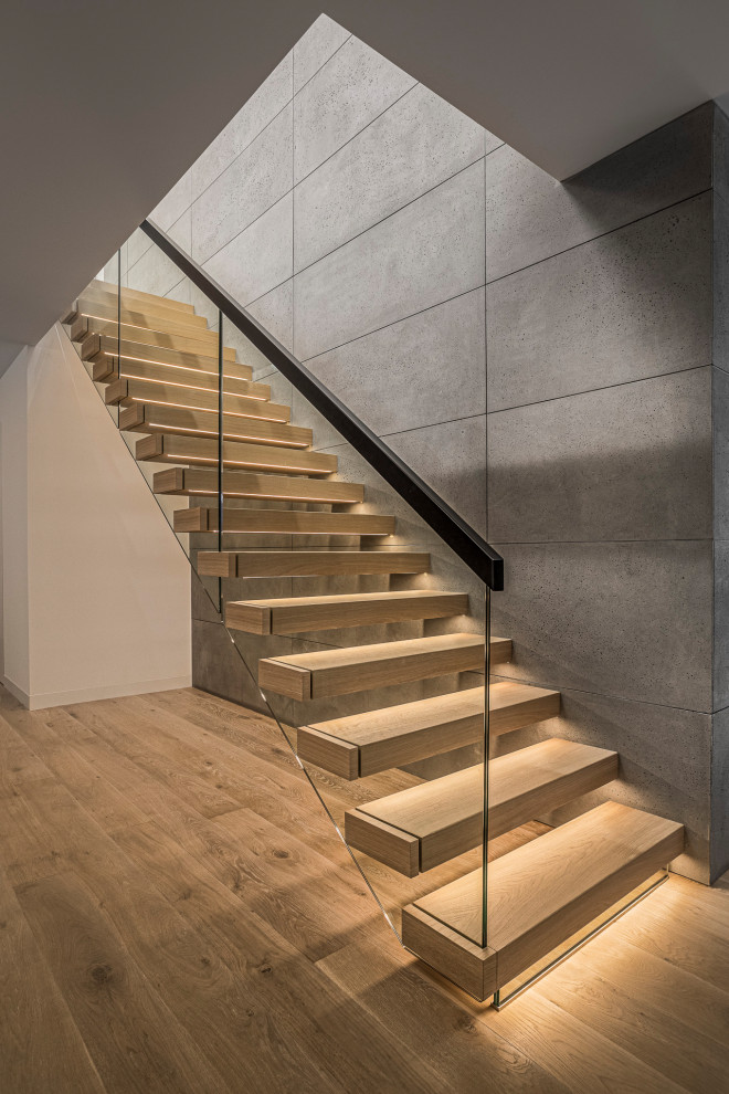 Aménagement d'un escalier droit contemporain de taille moyenne avec des marches en bois peint et un garde-corps en verre.
