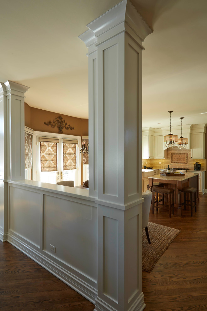 Inspiration for a mid-sized transitional u-shaped medium tone wood floor eat-in kitchen remodel in Tampa with a farmhouse sink, white cabinets, quartzite countertops, beige backsplash, ceramic backsplash, paneled appliances and an island