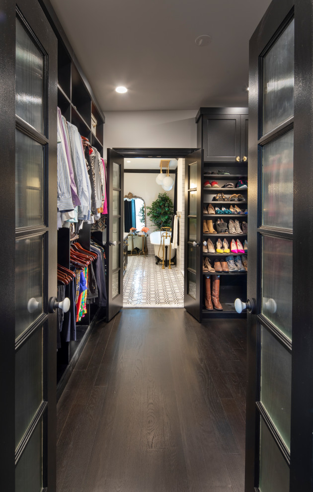 Стильный дизайн: гардеробная комната среднего размера, унисекс в стиле фьюжн с темным паркетным полом и черным полом - последний тренд