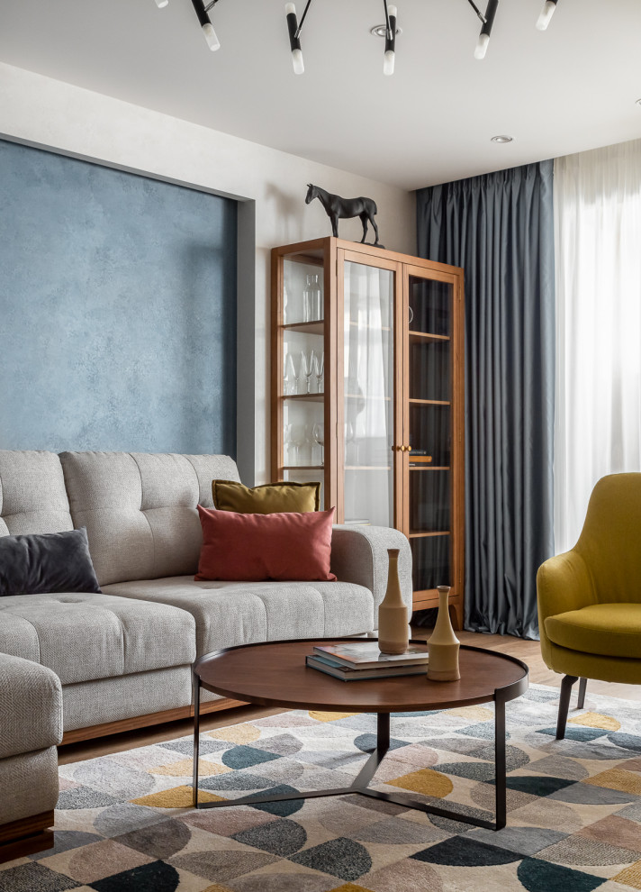 Imagen de salón abierto, gris y blanco y blanco contemporáneo de tamaño medio con paredes azules, suelo de madera clara, televisor colgado en la pared y suelo marrón