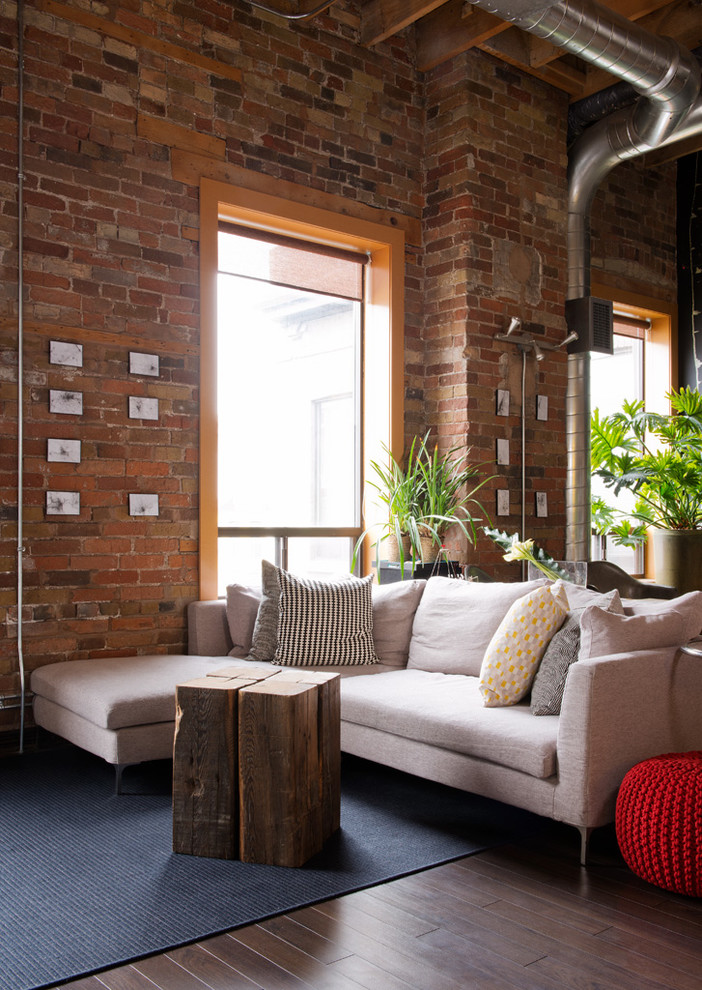 Photo of an industrial open concept living room in Toronto with dark hardwood floors, no fireplace and brown floor.