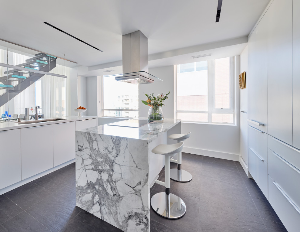 Small contemporary u-shaped separate kitchen in Toronto with a double-bowl sink, flat-panel cabinets, white cabinets, marble benchtops, glass sheet splashback, stainless steel appliances, slate floors, with island, black floor and white benchtop.