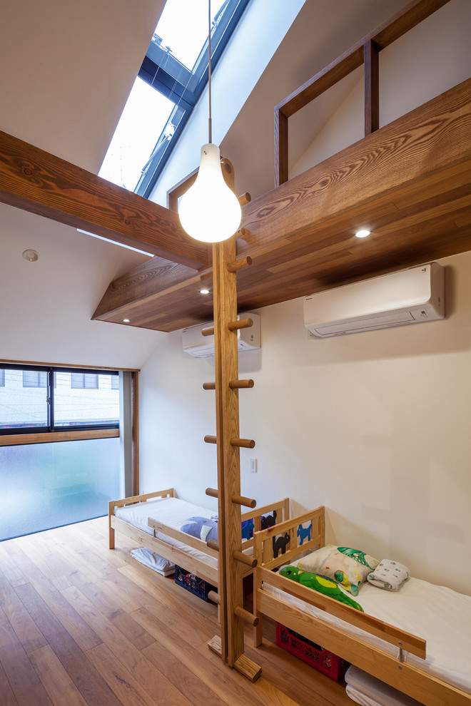 This is an example of a contemporary kids' room in Osaka with white walls and medium hardwood floors.