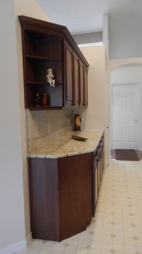 Photo of a mid-sized traditional galley eat-in kitchen in Orlando with raised-panel cabinets and dark wood cabinets.