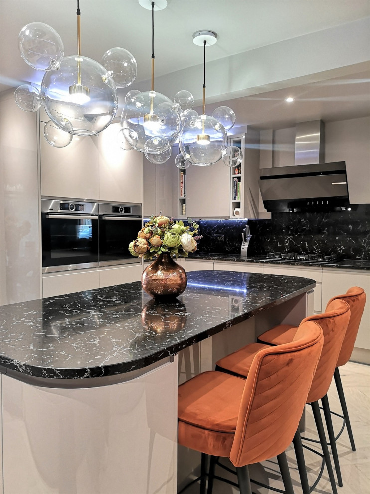 Large contemporary open plan kitchen in London with flat-panel cabinets, beige cabinets, quartzite benchtops, multi-coloured splashback, engineered quartz splashback, black appliances, light hardwood floors, with island, beige floor, multi-coloured benchtop and recessed.
