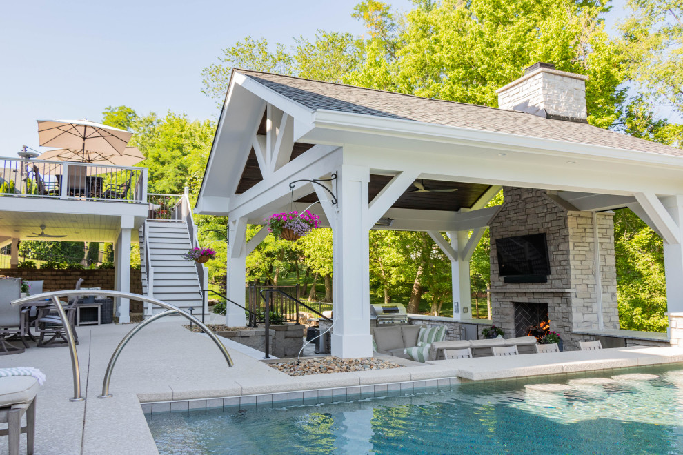 This is an example of an expansive traditional backyard patio in St Louis with with fireplace, concrete pavers and a gazebo/cabana.