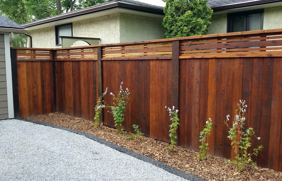 This is an example of a large transitional backyard garden in Calgary.