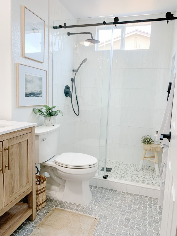 Источник вдохновения для домашнего уюта: маленькая ванная комната в стиле неоклассика (современная классика) с бежевыми фасадами, душем в нише, белой плиткой, керамической плиткой, белыми стенами, мраморным полом, врезной раковиной, столешницей из искусственного кварца, серым полом, душем с раздвижными дверями, белой столешницей, тумбой под одну раковину и напольной тумбой для на участке и в саду