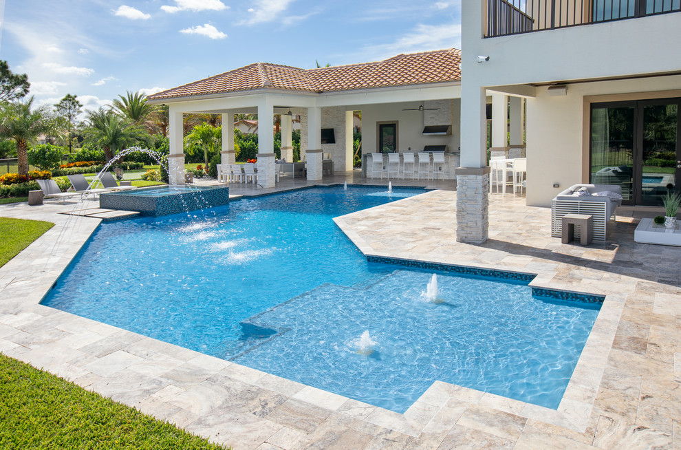 This is an example of a large transitional backyard custom-shaped lap pool in Miami with a water feature and natural stone pavers.