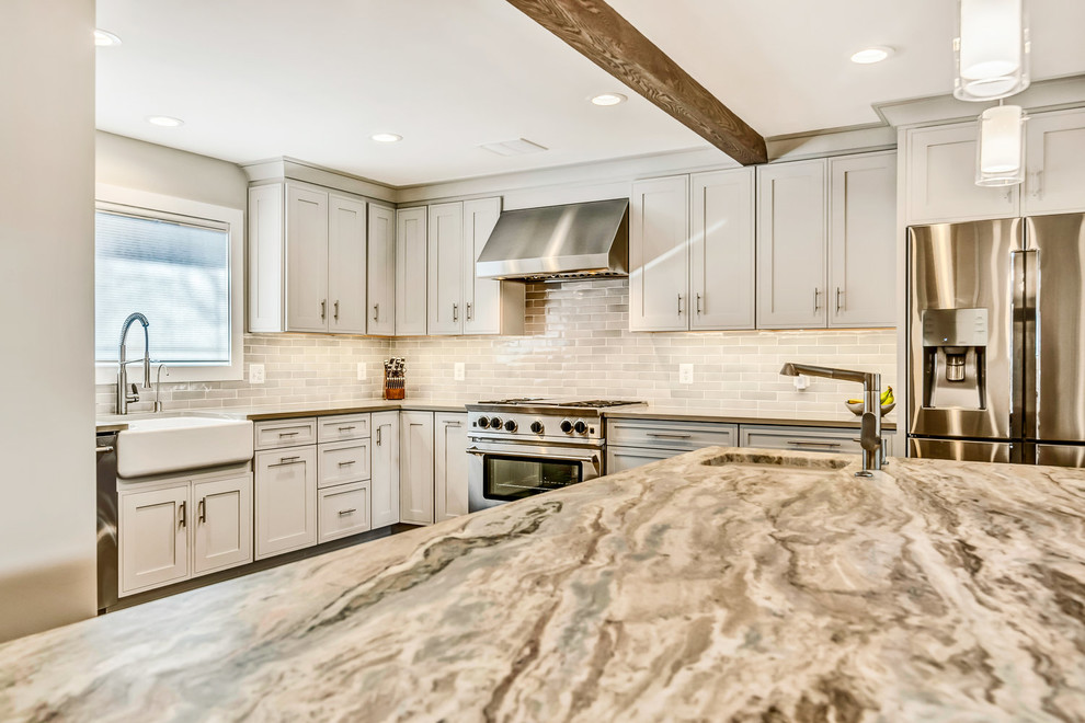 Inspiration for a transitional medium tone wood floor and brown floor eat-in kitchen remodel in DC Metro with a farmhouse sink, shaker cabinets, white cabinets, granite countertops, white backsplash, subway tile backsplash, stainless steel appliances, an island and multicolored countertops