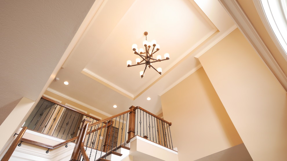 Large transitional medium tone wood floor foyer photo with beige walls and a dark wood front door