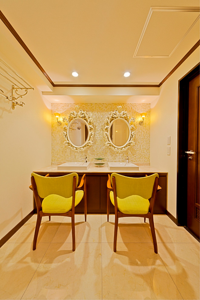 This is an example of a traditional powder room in Fukuoka with flat-panel cabinets, medium wood cabinets, white tile, yellow tile, beige walls, marble floors, a vessel sink, marble benchtops and beige floor.