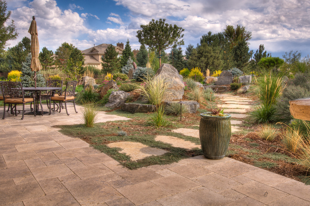 Design ideas for a large traditional backyard garden in Denver with natural stone pavers.
