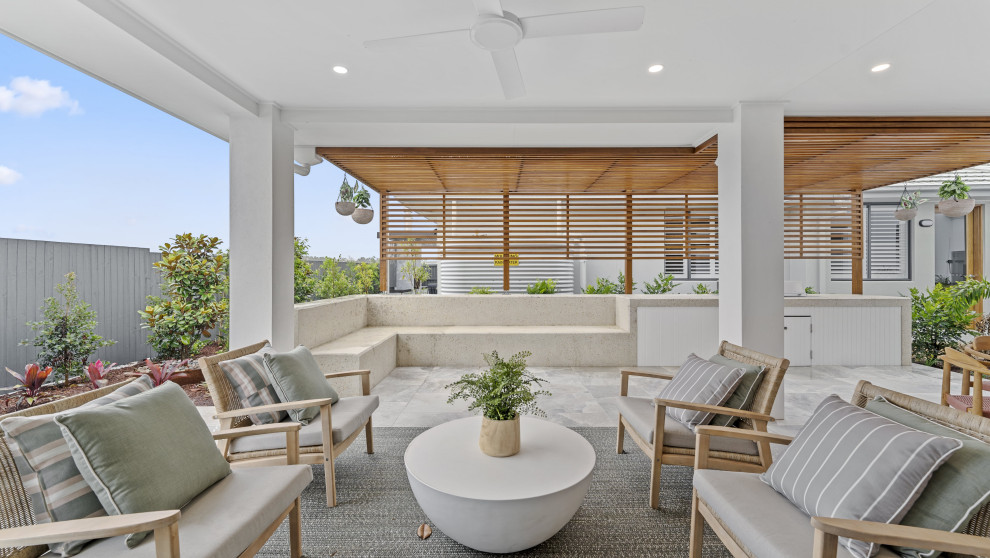 This is an example of a large contemporary backyard patio in Sunshine Coast with a roof extension.