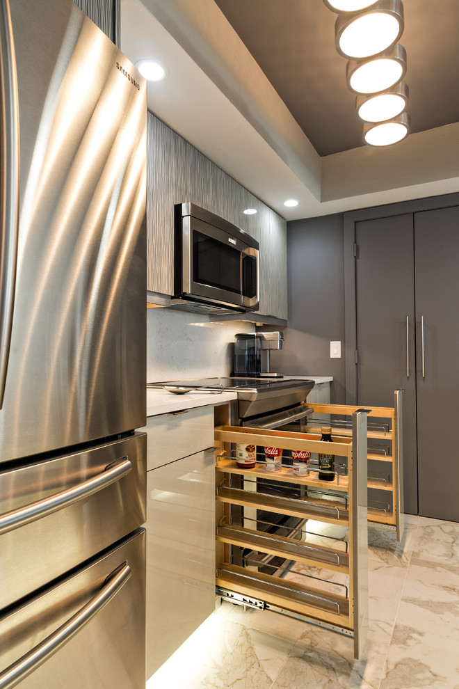 This is an example of a small contemporary galley eat-in kitchen in Miami with a single-bowl sink, grey cabinets, quartz benchtops, white splashback, stone slab splashback, stainless steel appliances, porcelain floors, flat-panel cabinets and no island.