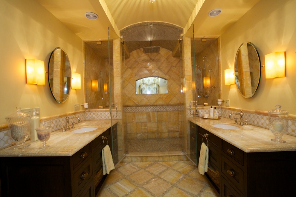 Large mediterranean bathroom in San Francisco with an undermount sink, onyx benchtops, white tile, stone slab, yellow walls, marble floors, furniture-like cabinets, dark wood cabinets, a freestanding tub and with a sauna.