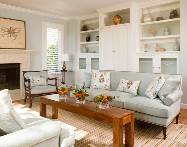 This is an example of a mid-sized beach style enclosed living room in Charleston with blue walls, terra-cotta floors, a standard fireplace, a stone fireplace surround and a concealed tv.