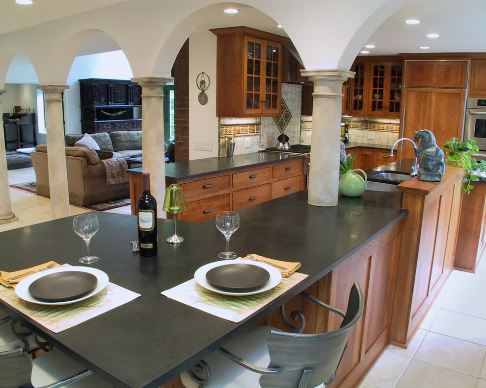 This is an example of a mediterranean kitchen in Boston with glass-front cabinets and granite benchtops.