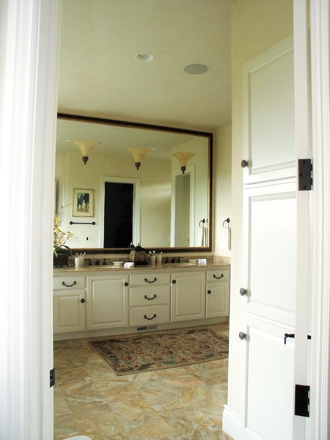 Example of a transitional master bathroom design with raised-panel cabinets, white cabinets, beige walls, an undermount sink and granite countertops