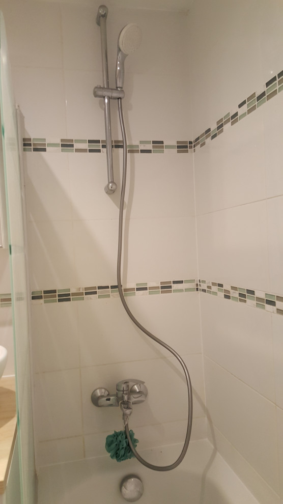 Small contemporary master wet room bathroom in Paris with white cabinets, an undermount tub, white tile, glass tile, white walls, ceramic floors, a drop-in sink, laminate benchtops, grey floor and a hinged shower door.