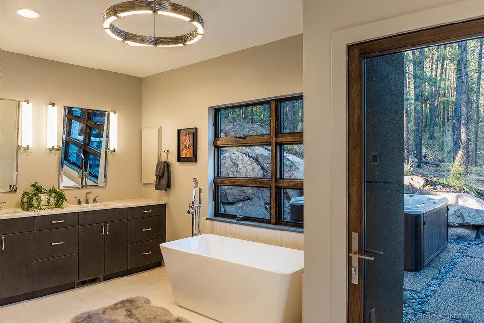 This is an example of a large contemporary master bathroom in Albuquerque with a freestanding tub, yellow walls, porcelain floors, an undermount sink, engineered quartz benchtops, white floor and white benchtops.
