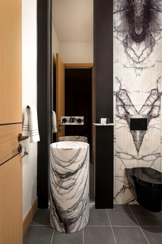 Inspiration for a contemporary black and white tile gray floor powder room remodel in Phoenix with a wall-mount toilet, white walls and a pedestal sink