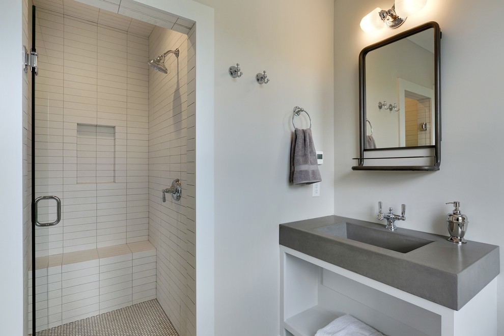 Photo of a mid-sized country 3/4 bathroom in Minneapolis with open cabinets, white cabinets, an alcove shower, a two-piece toilet, white tile, grey walls, concrete benchtops, ceramic tile, pebble tile floors and an integrated sink.