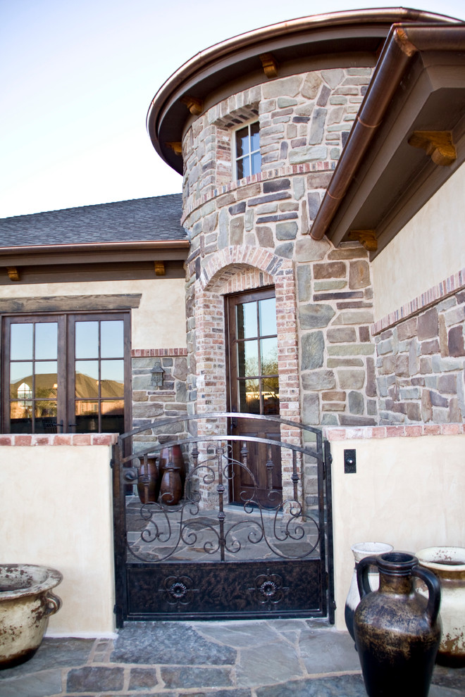 Photo of a country one-storey exterior in Austin with stone veneer.