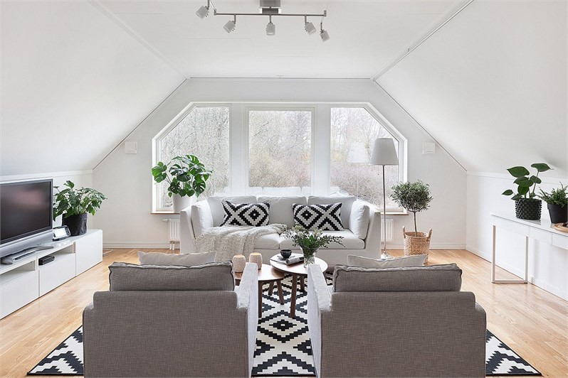Scandinavian enclosed family room in Orebro with white walls, medium hardwood floors and a freestanding tv.