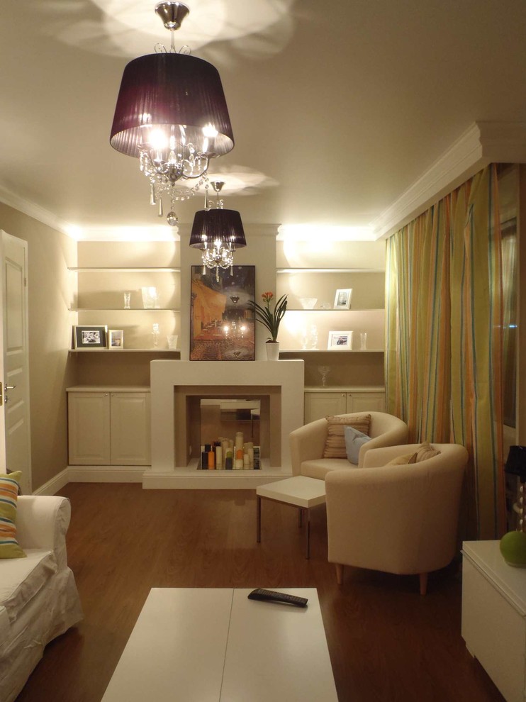 Small transitional enclosed living room in Moscow with a library, beige walls, laminate floors, a standard fireplace, a plaster fireplace surround, a freestanding tv and brown floor.
