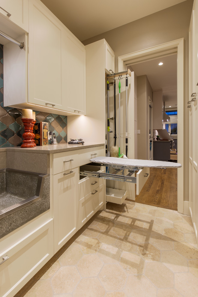 This is an example of a large modern galley utility room in Austin with an utility sink, shaker cabinets, white cabinets, quartz benchtops, a side-by-side washer and dryer and brown walls.