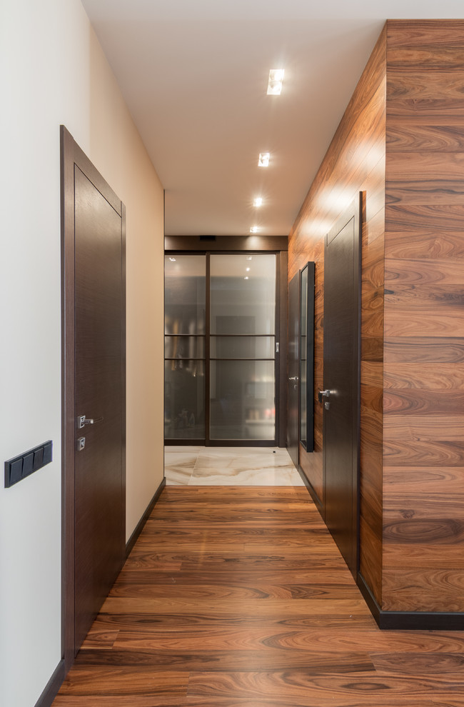 Large contemporary hallway in Other with brown walls and medium hardwood floors.