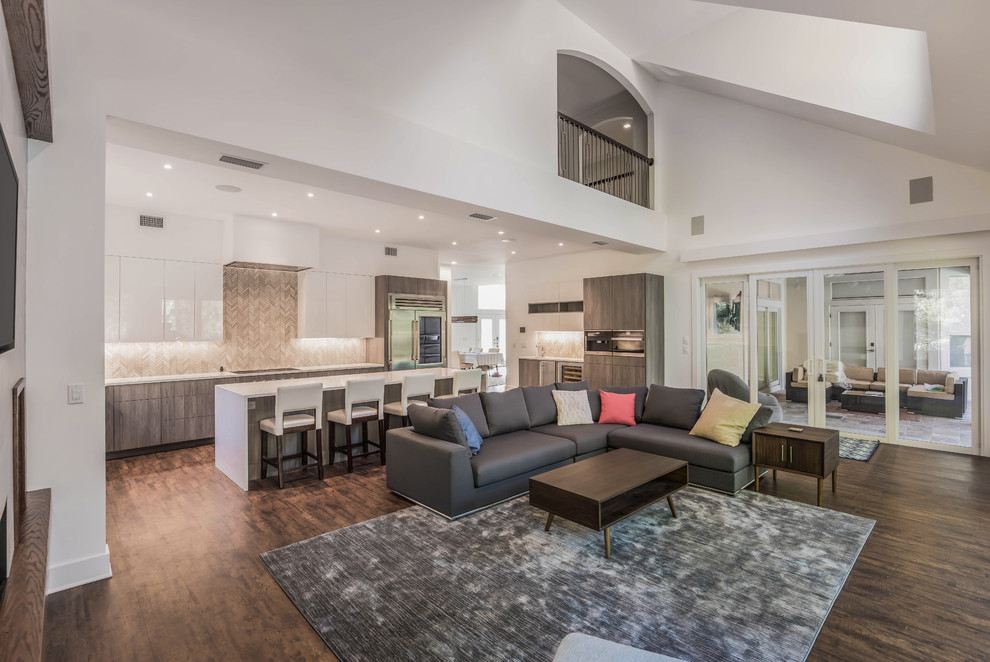 This is an example of a large contemporary formal open concept living room in Jacksonville with a ribbon fireplace, a tile fireplace surround, brown floor, white walls, vinyl floors and a wall-mounted tv.