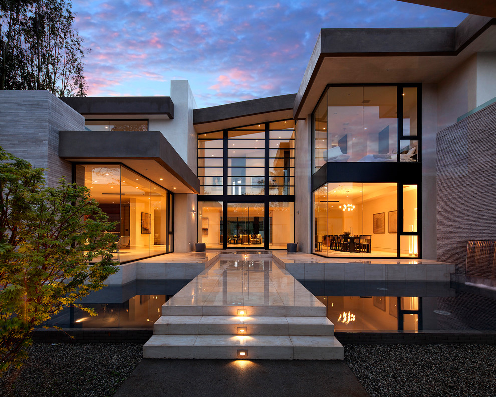 Large contemporary two-storey glass beige house exterior in Los Angeles.