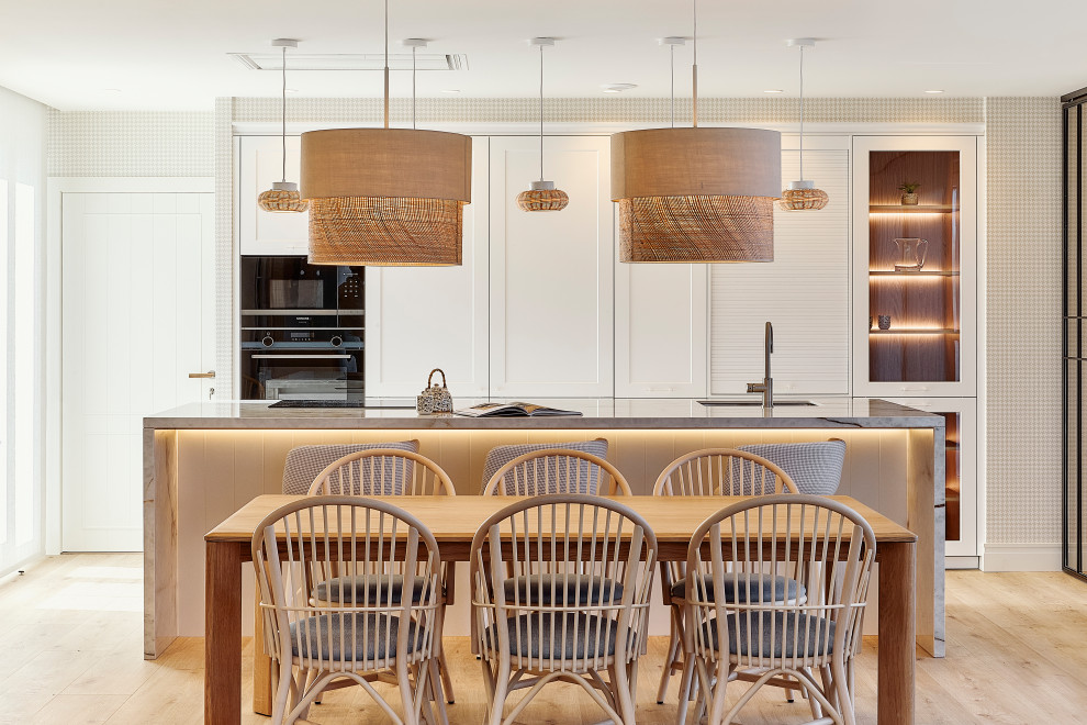 Modelo de comedor de cocina tradicional renovado grande sin chimenea con paredes beige, suelo laminado, suelo marrón y papel pintado