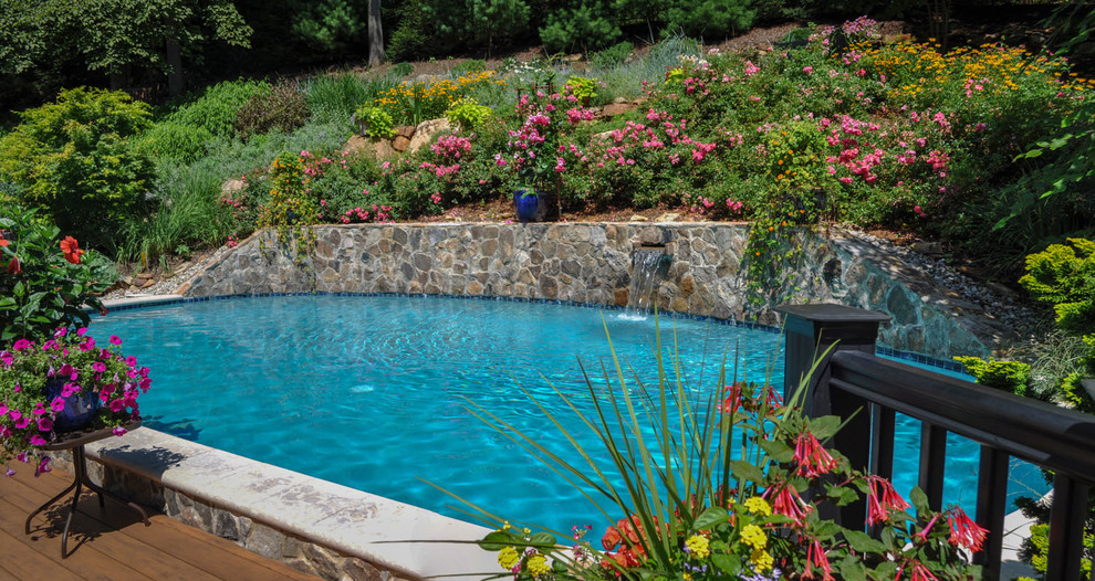 Inspiration for a mid-sized traditional backyard round lap pool in New York with a water feature and decking.