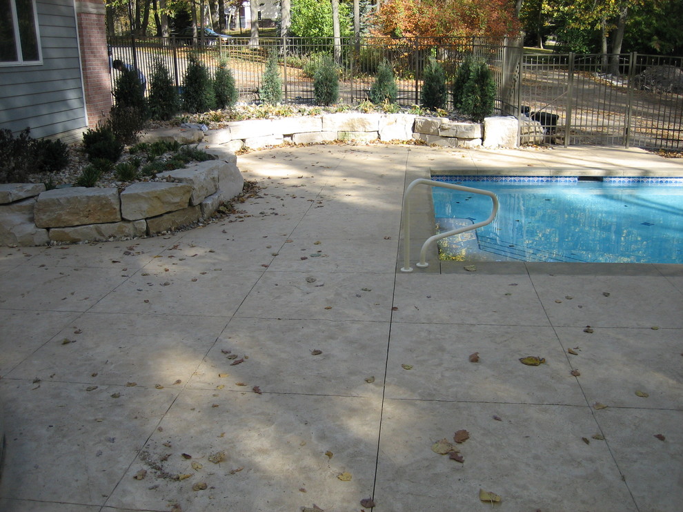 Large transitional backyard concrete paver and rectangular natural pool house photo in Cedar Rapids
