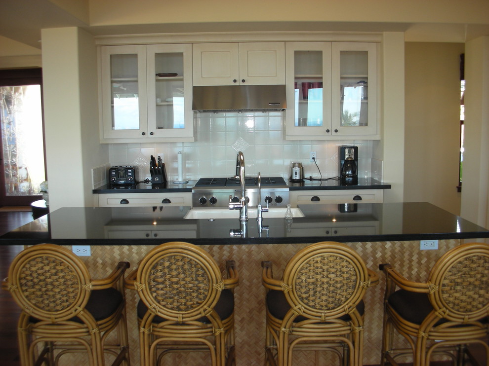 Photo of a tropical kitchen in Hawaii with glass-front cabinets and granite benchtops.