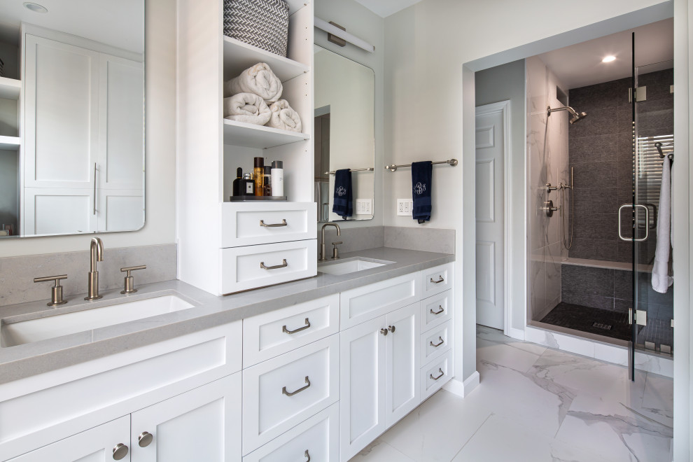 This is an example of a large transitional master bathroom in Los Angeles with shaker cabinets, white cabinets, an alcove shower, a one-piece toilet, white tile, porcelain tile, grey walls, porcelain floors, an undermount sink, engineered quartz benchtops, white floor, a hinged shower door, grey benchtops, an enclosed toilet, a double vanity and a built-in vanity.