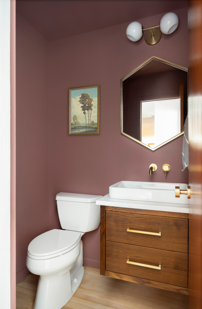 Inredning av ett modernt litet vit vitt badrum med dusch, med släta luckor, skåp i mellenmörkt trä, en toalettstol med separat cisternkåpa, rosa väggar, ljust trägolv, ett fristående handfat och bänkskiva i kvarts