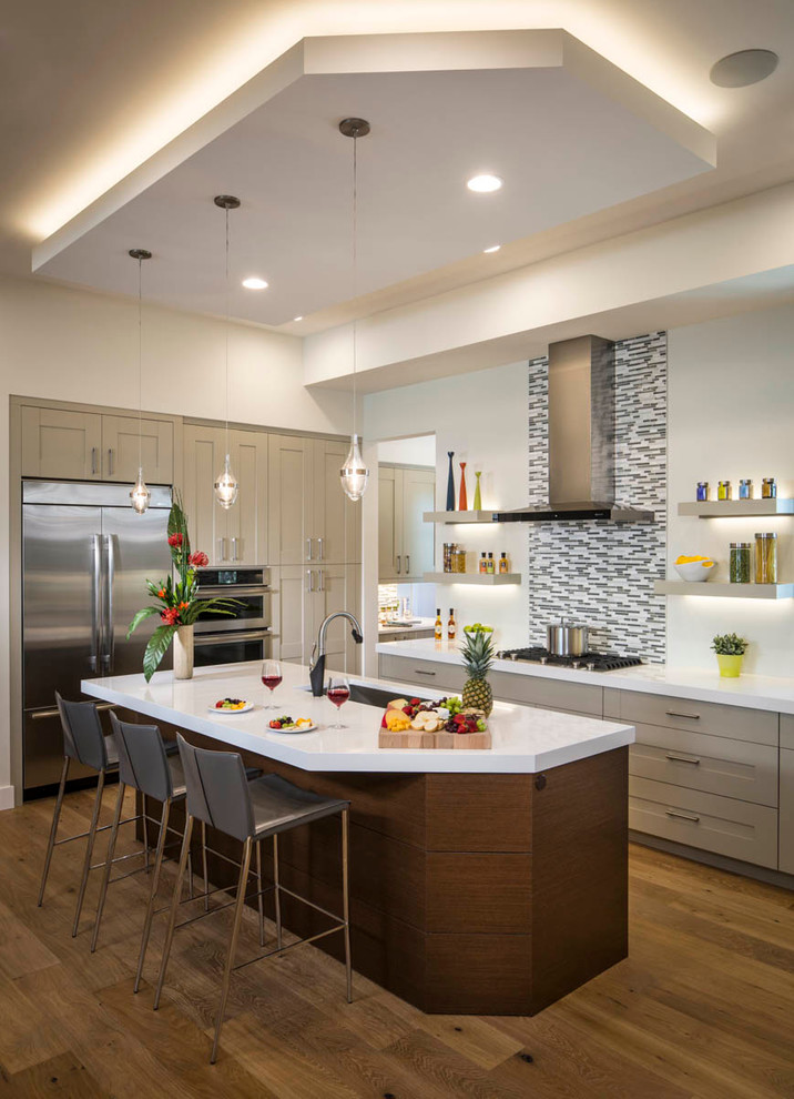 Transitional medium tone wood floor kitchen photo in Tampa with stainless steel appliances, an island, an undermount sink, recessed-panel cabinets, gray cabinets, multicolored backsplash and mosaic tile backsplash