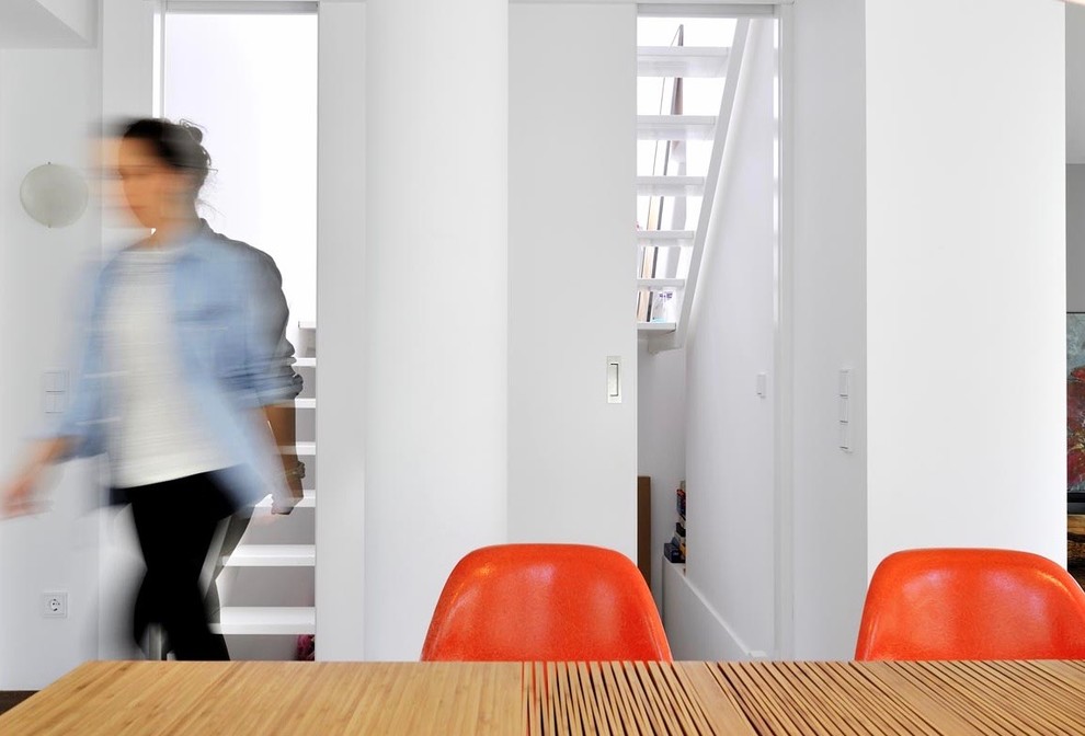 Offenes, Geräumiges Modernes Esszimmer mit weißer Wandfarbe, dunklem Holzboden, Kamin und braunem Boden in München