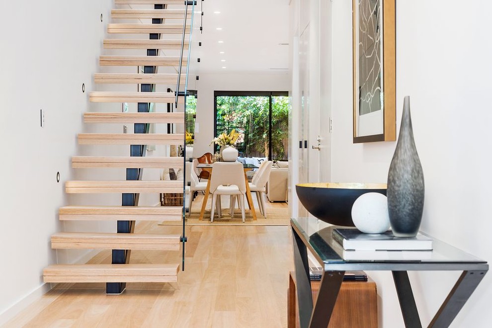 This is an example of a mid-sized contemporary hallway in Sydney with white walls and light hardwood floors.