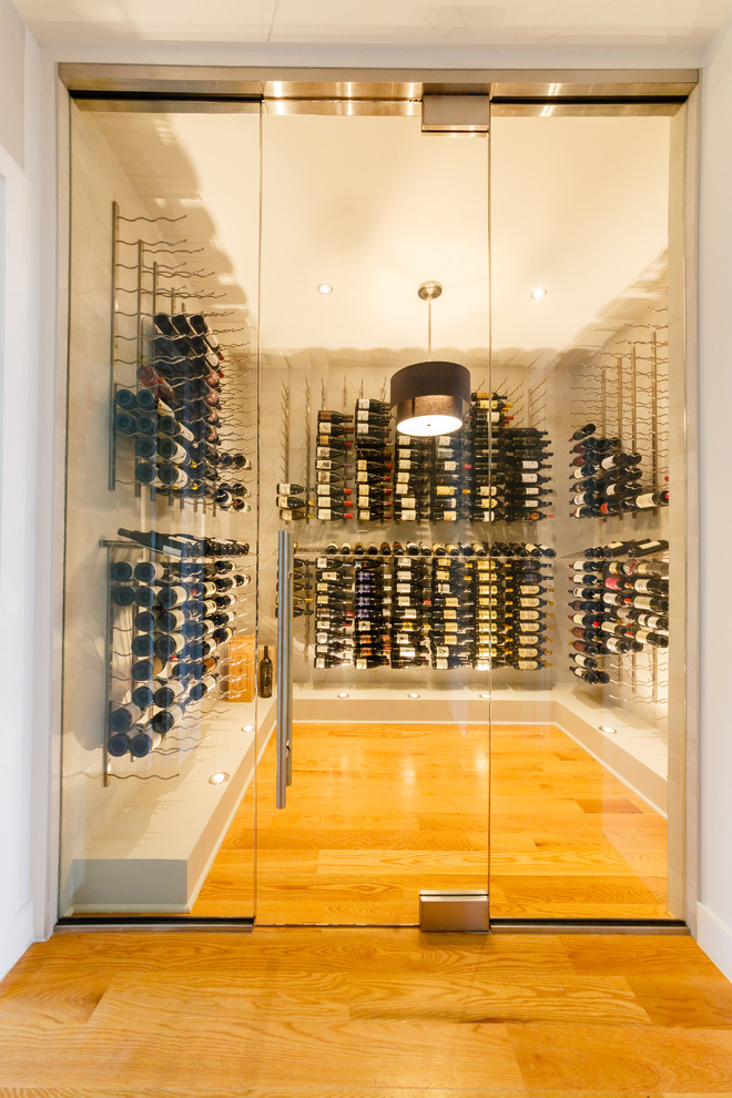 Design ideas for a mid-sized contemporary wine cellar in New York with light hardwood floors, display racks and yellow floor.