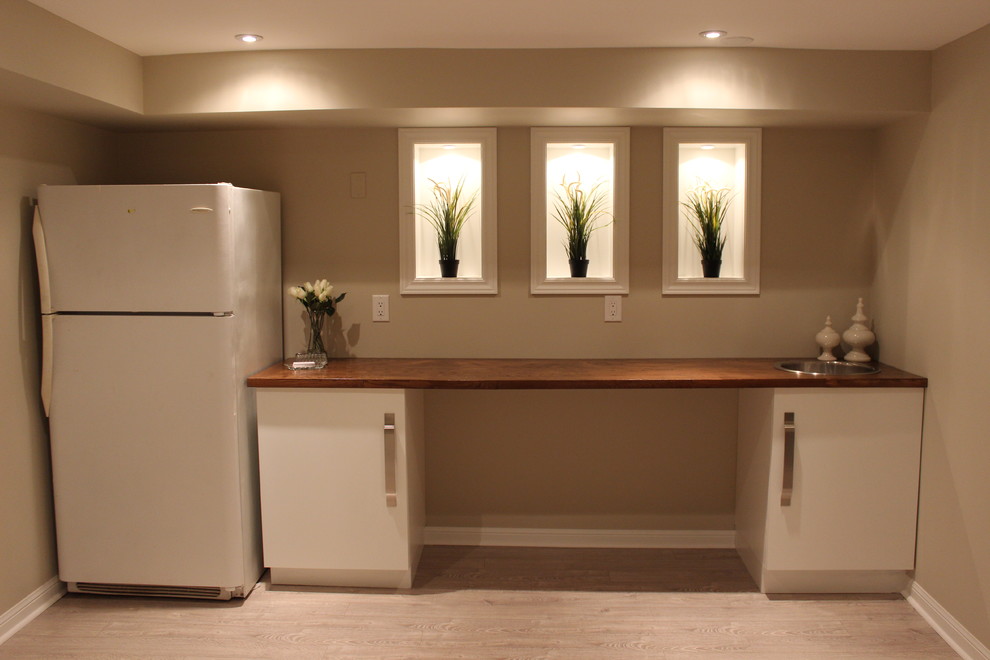 Design ideas for a large contemporary look-out basement in Toronto with beige walls and light hardwood floors.