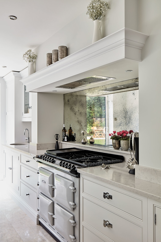 Large contemporary l-shaped eat-in kitchen in Manchester with an integrated sink, shaker cabinets, grey cabinets, quartzite benchtops, metallic splashback, mirror splashback, coloured appliances, marble floors, with island, beige floor and white benchtop.
