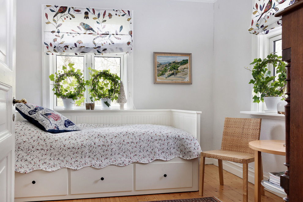 Inspiration for a country guest bedroom in Gothenburg with white walls and medium hardwood floors.