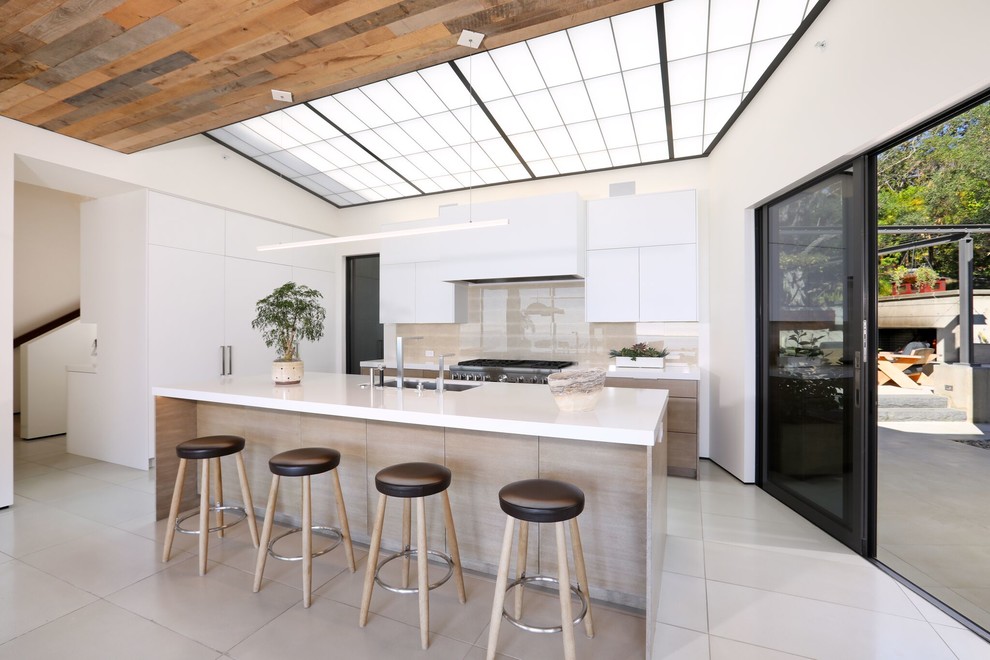 Design ideas for a contemporary l-shaped kitchen in Orange County with an undermount sink, flat-panel cabinets, white cabinets, grey splashback, with island, grey floor and white benchtop.
