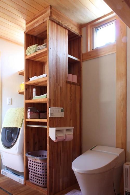 Photo of a small asian powder room in Other with medium wood cabinets, a one-piece toilet, white walls, medium hardwood floors, a drop-in sink, wood benchtops, orange floor, orange benchtops, a freestanding vanity and wood.